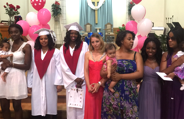 Women graduating, in robes, lined up for a picture